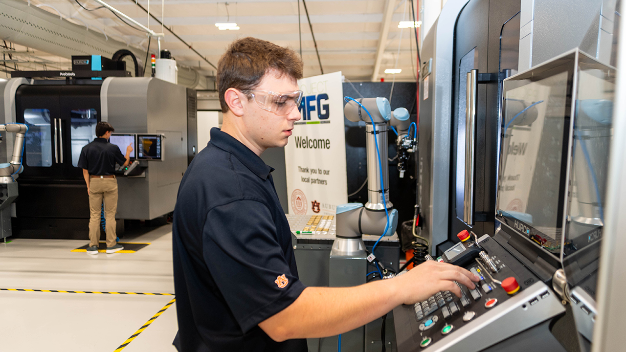 man types on an advanced manufacturing machine